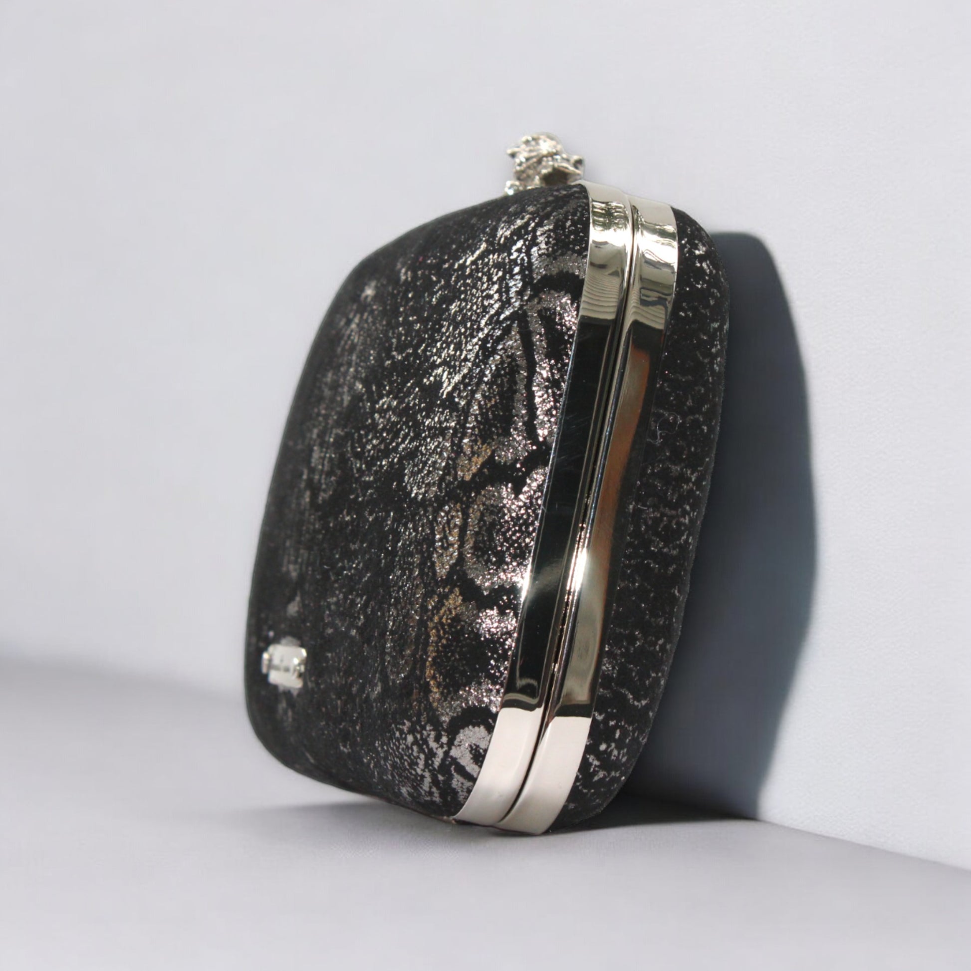 This bag is handcrafted with Italian l METALLIC SILVER SNAKE Print On Black Suede, Thin, Soft Italian Goatskin Goat Leather. The bag is topped with a silver-toned owl and a silver-tone frame.&nbsp;&nbsp. This eye-catching clutch bag is the ultimate evening and day accessory, which&nbsp;can be carried by hand or worn draped over the shoulder with the detachable chain strap.
Our Black Owl&nbsp; Woman Clutch Bag is whimsical and elegant. It is a rectangular clutch bag. 
