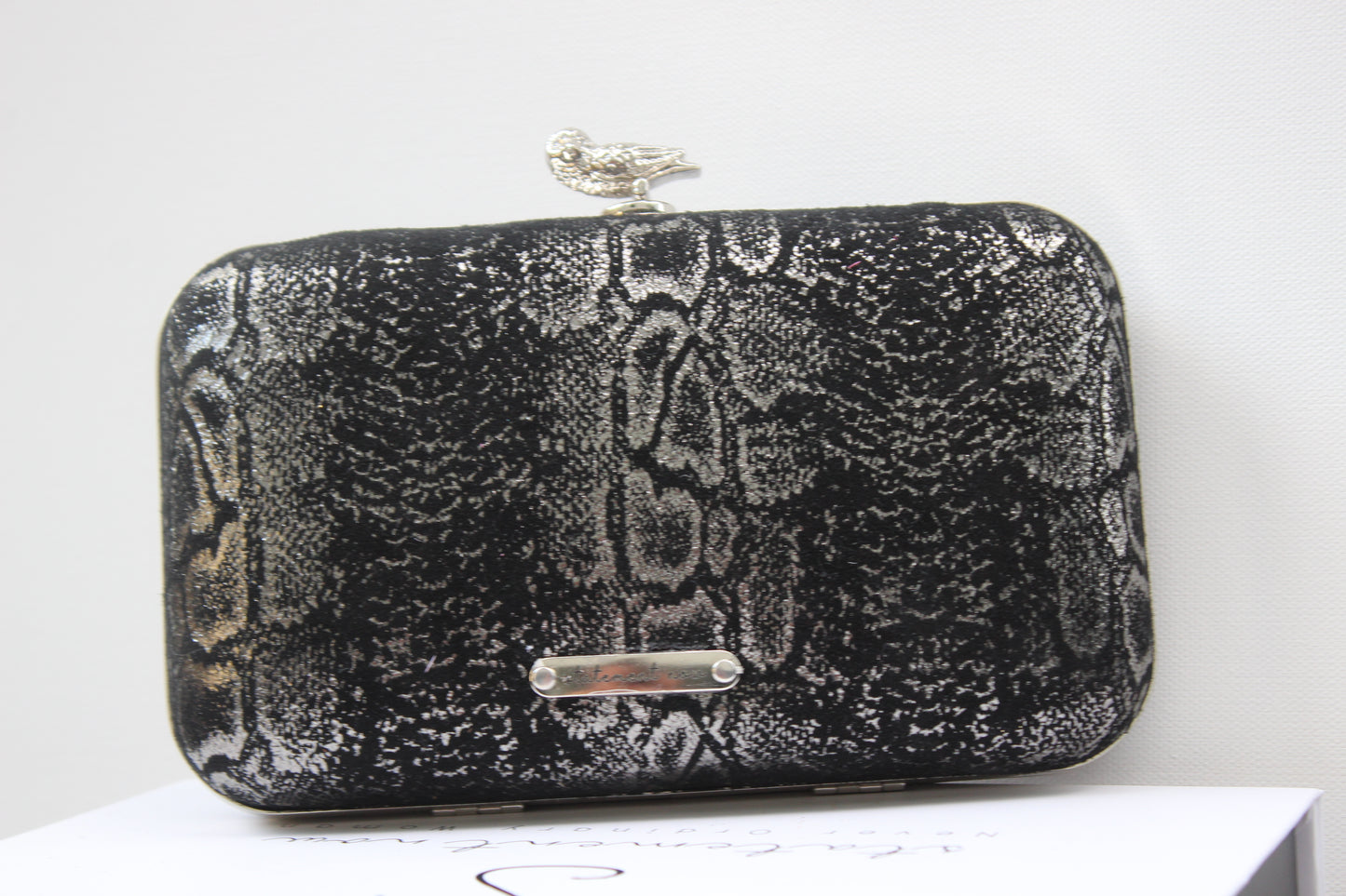 This bag is handcrafted with Italian l METALLIC SILVER SNAKE Print On Black Suede, Thin, Soft Italian Goatskin Goat Leather. The bag is topped with a silver-toned owl and a silver-tone frame.&nbsp;&nbsp. This eye-catching clutch bag is the ultimate evening and day accessory, which&nbsp;can be carried by hand or worn draped over the shoulder with the detachable chain strap.
Our Black Owl Woman Clutch Bag is whimsical and elegant. It is a rectangular clutch bag. 

